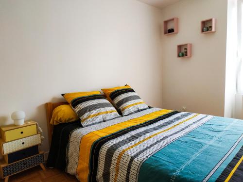 - une chambre avec un lit et une couverture colorée dans l'établissement Place d'Arradon, à Arradon