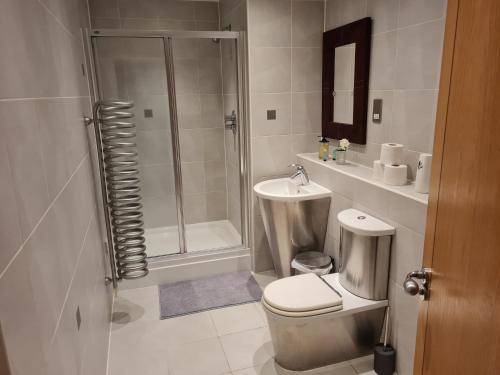 a bathroom with a shower and a toilet and a sink at Cardiff City centre Apartment lifestyle!! in Cardiff