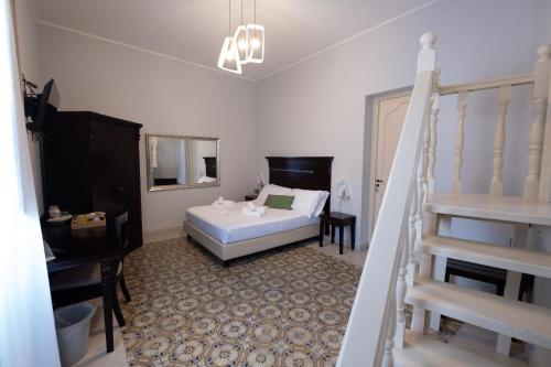 サンタ・フラーヴィアにあるHotel Borgo di Ciàulaのベッドと階段のある寝室
