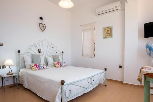 een slaapkamer met een bed met witte muren en een klok bij Hatzidakis Beach Retreat in Ierápetra