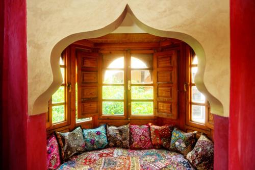 Habitación con sofá frente a una ventana en Riad Roxanne en Marrakech