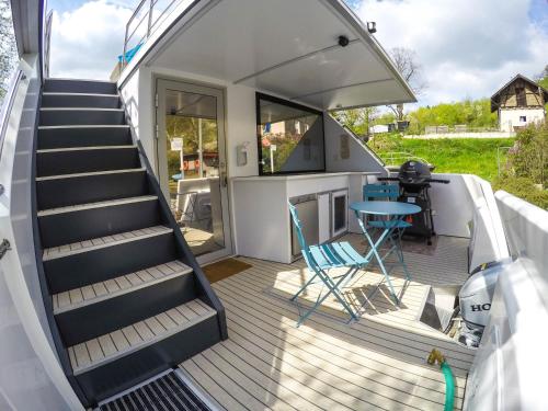 a deck with stairs and a table on a boat at Hausboot Schleuseninsel in Lahnstein
