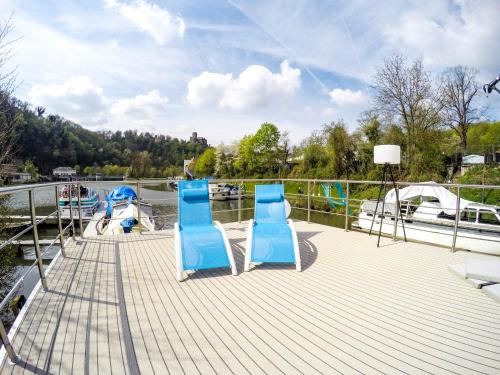 two blue chairs sitting on the deck of a boat at Hausboot Schleuseninsel in Lahnstein