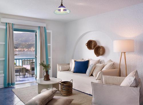 a living room with a white couch and a window at Nikis Village in Poros