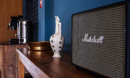 a white vase sitting on a table next to a tv at Hotel Stancia Kazbegi - City Center in Stepantsminda