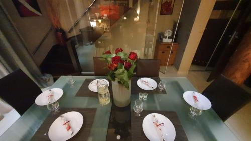 uma mesa com pratos e um vaso de rosas em Dom na Leszczynowej Górce - plaża, las em Ełk