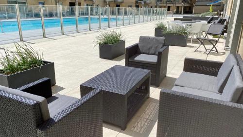 a patio with chairs and tables and a pool at Deluxe Apartment with Shared Pool in Ostend
