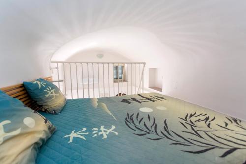 een slaapkamer met een bed met een blauw dekbed bij House In the Tower in Amalfi