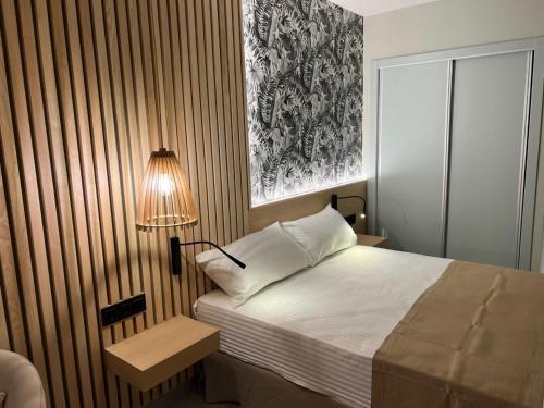 a bedroom with a bed and a lamp next to it at Hotel Noy in Almuñécar