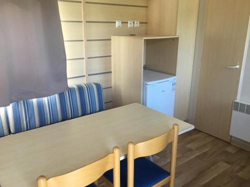 Habitación pequeña con mesa y nevera. en Le coin tranquille, en Morosaglia
