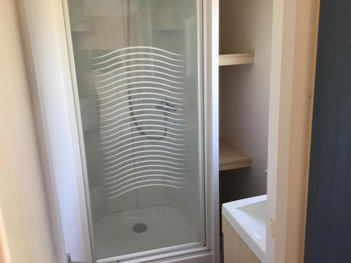 La salle de bains est pourvue d'une douche en verre et d'un lavabo. dans l'établissement Le coin tranquille, à Morosaglia