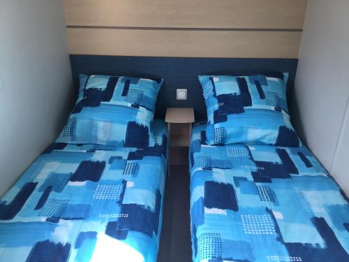 deux lits côte à côte dans une pièce dans l'établissement Le coin tranquille, à Morosaglia