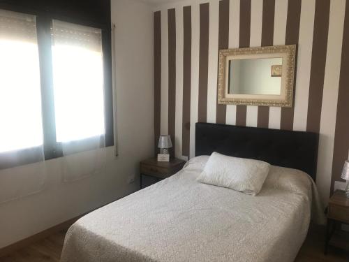 um quarto com uma cama e um espelho na parede em SALOU al LADO de PLAYA: Bonito Apartamento, WiFi em Salou