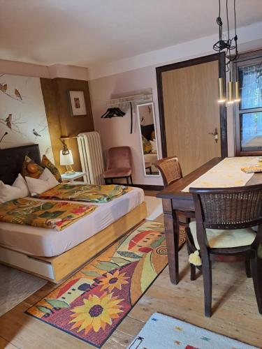 een slaapkamer met een bed en een tafel en een eetkamer bij Privatzimmer im Gasthaus Engel in Dornbirn