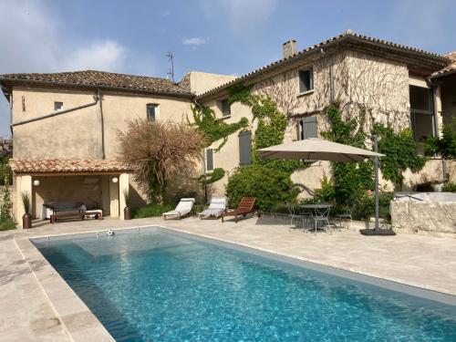 une maison avec une piscine devant une maison dans l'établissement Le mas de Marie, à Taulignan