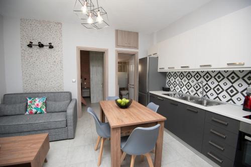 Una cocina y una sala de estar con una mesa y un sofá. en ENIO AXD guest house with private parking, en Alexandroupoli