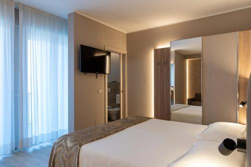 a hotel room with a bed and a television at Hotel Lungomare in Cesenatico