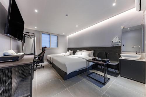 a hotel room with a bed and a sink at Hotel the Rest in Cheongju