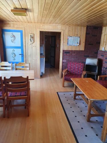 uma sala de estar com mesa e cadeiras em Bjørklund em Geilo