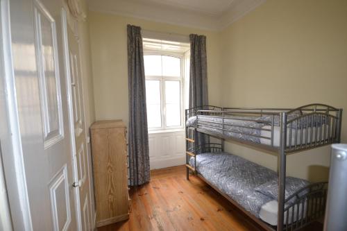a room with two bunk beds and a window at Sport Hostel Figueira da Foz in Figueira da Foz