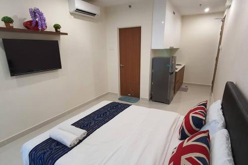 een hotelkamer met een bed en een televisie bij Kozi Square New SGH Cozy Home LV7D in Kuching