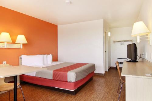a room with a bed and a desk and a television at Motel 6-Fort Stockton, TX in Fort Stockton