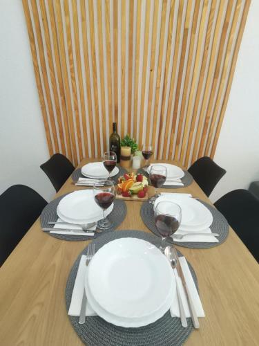 a wooden table with plates and glasses of wine at King's Cave deluxe in Jajce