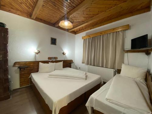 a room with two beds in a room with a tv at Pensiunea Mioritica in Sibiel