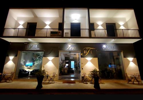 a building with a balcony with tables and chairs at Hotel TEA - Praia a Mare in Praia a Mare