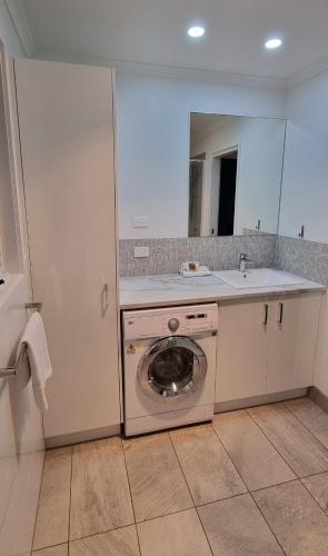a kitchen with a washing machine and a sink at Bells Beach Cottages in Bellbrae