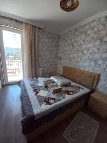 a bedroom with a bed in a room with a window at The Yellow Brick Apartment in Tbilisi City