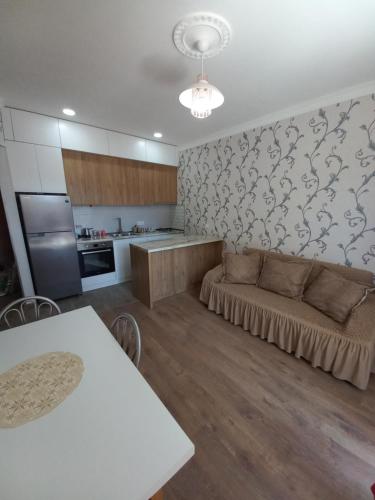The Yellow Brick Apartment في تبليسي: غرفة معيشة مع أريكة ومطبخ