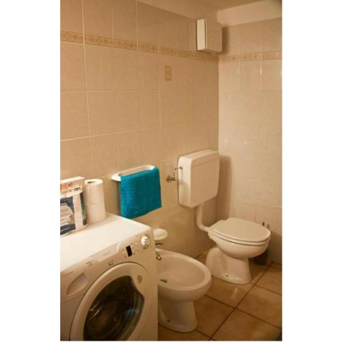 a bathroom with a washing machine and a toilet at STOP & STARE STARS in Lignan