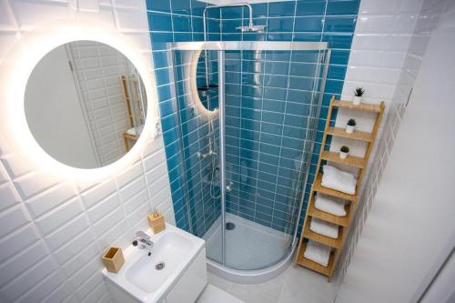 a bathroom with a sink and a shower and a mirror at ApartManó in Balatonfüred