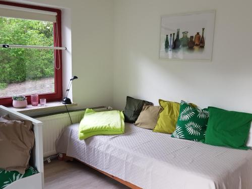 um quarto com uma cama com almofadas verdes em Charmante Einliegerwohnung em Kiel