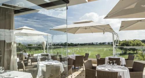 a restaurant with tables and umbrellas with a view at Havre de paix au BahiaGolf Beach, Résidence Front Mer in Bouznika