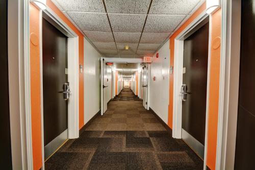 a hallway in an office building with orange and white walls at Motel 6-Newport, RI in Newport