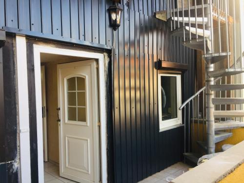 a hallway with a white door and a staircase at Monteurwohnung, 2 Zimmer, Küche,Bad in Staufenberg