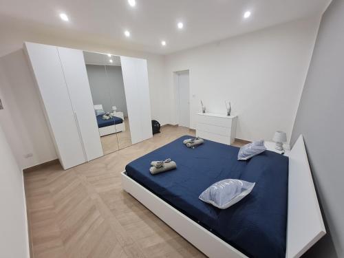 1 dormitorio con 1 cama azul en una habitación blanca en Sweet Home Airport en Catania