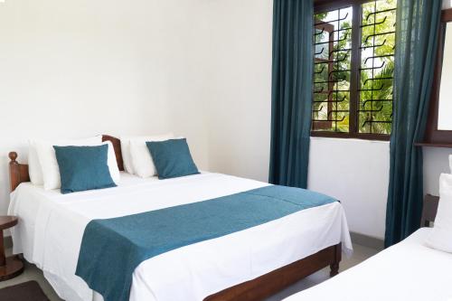 a bedroom with two beds and a stained glass window at Villa Sarakkuwa in Pamunugama