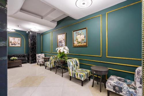 a waiting room with green walls and chairs at La Casona Hotel in Ho Chi Minh City