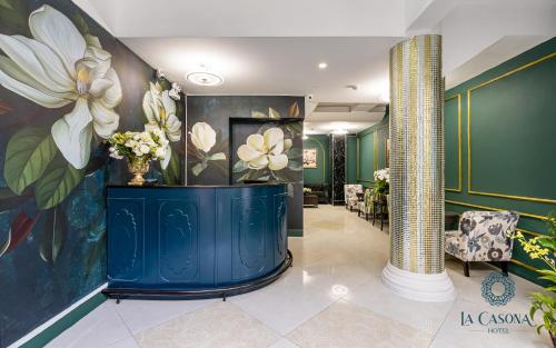 a lobby with a large painting of flowers on the wall at La Casona Hotel in Ho Chi Minh City