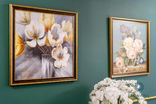 two framed pictures of flowers on a wall at La Casona Hotel in Ho Chi Minh City