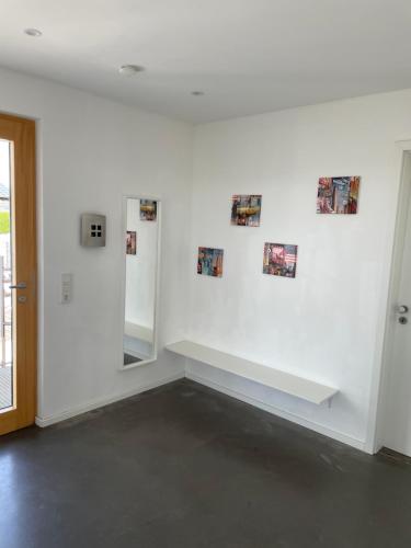 a white wall with a bench in a room at Haus am See in Calden