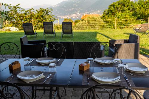 a blue table with chairs and a table with plates and glasses at Andirivieni Bellagio Guest House in Bellagio