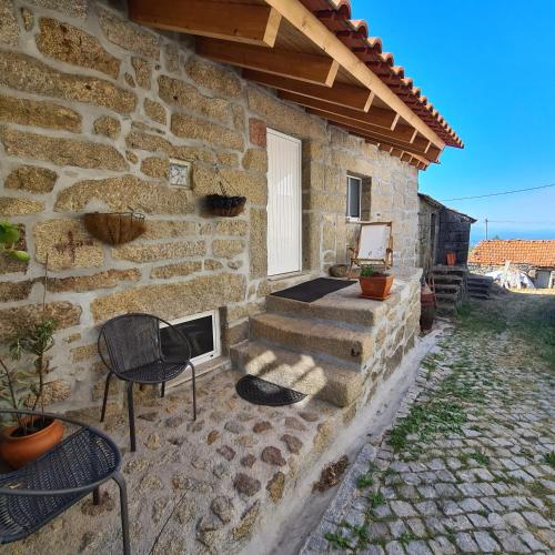 a stone house with two chairs and a fireplace at Isatour - Casa do Miradouro in Adsamo