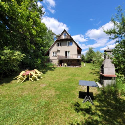 a house with a large yard with a horse statue at Dom Nad Jeziorem Staw in Gawrych Ruda