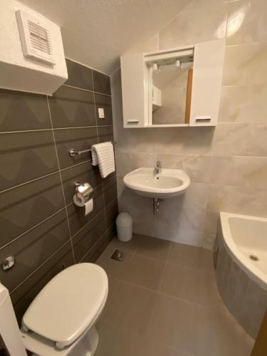 a bathroom with a white toilet and a sink at Milea in Makarska