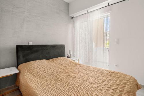 a bedroom with a bed and a large window at Holiday Apartment Glyfada in Athens
