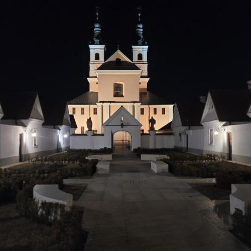 a large white church with two towers at night at Dom Nad Jeziorem Staw in Gawrych Ruda
